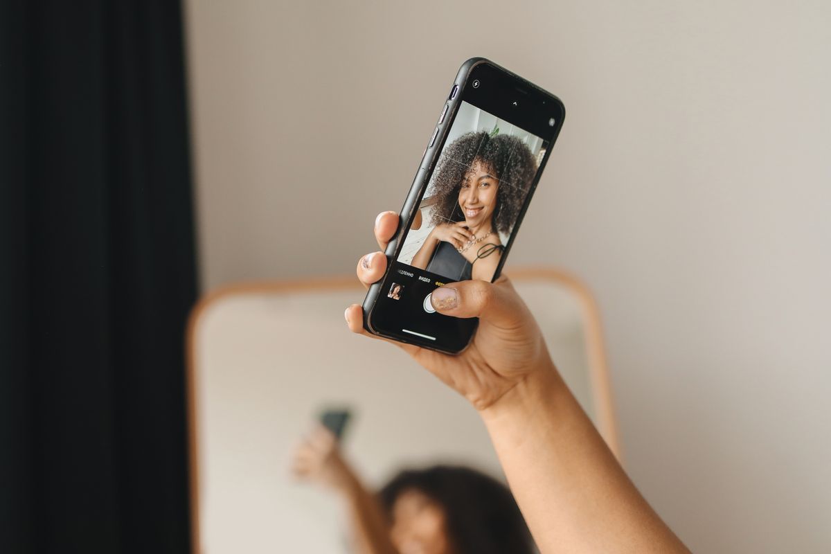 Woman using her smartphone camera indoors