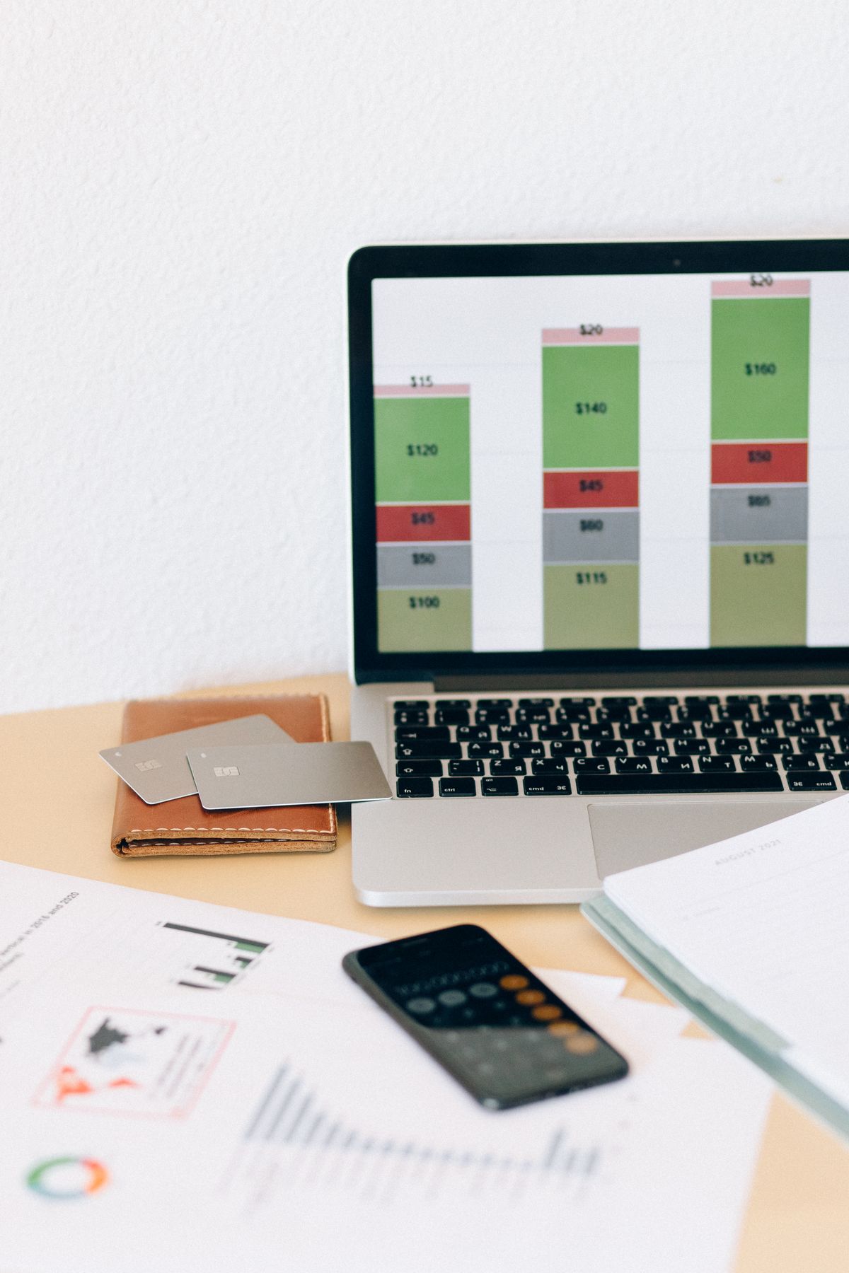 Financial charts on a laptop beside documents